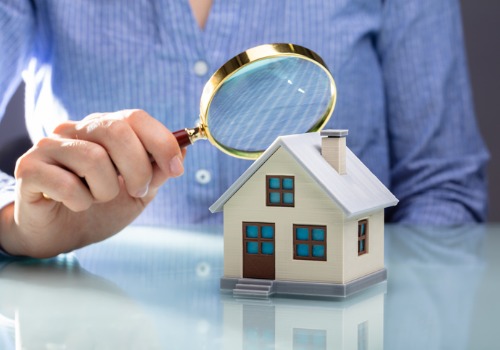 A lawyer holding a magnifying glass over a house, representing real estate law in Monmouth IL